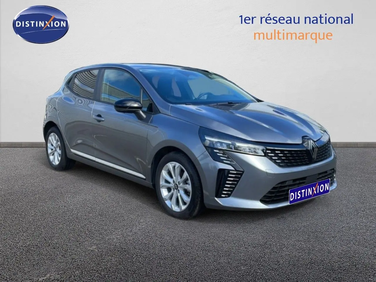 Renault Clio gris schiste métal vue 3/4 avant droit, avec calandre noire et feux LED distinctifs.