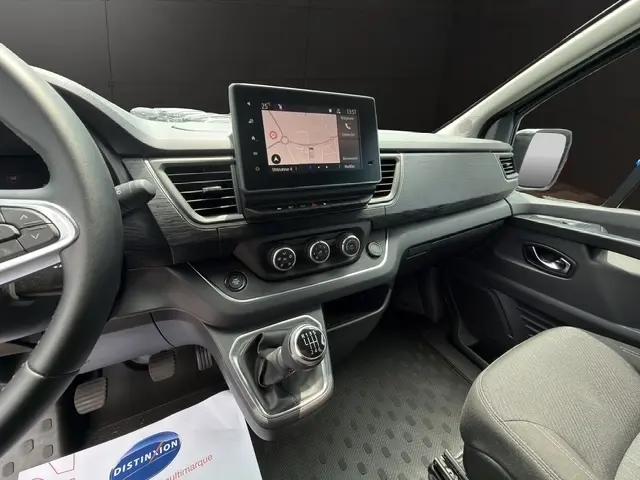 Vue intérieure côté conducteur du Nissan Primastar 2025 noir, avec écran tactile central et boîte manuelle.