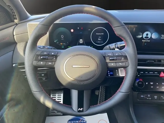 Vue intérieure centrée sur le volant cuir noir avec surpiqûres rouges du Hyundai Tucson 1.6 Hybrid N Line 2026.