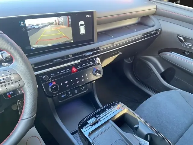Vue intérieure côté passager du tableau de bord et console centrale noire du Hyundai Tucson 1.6 Hybrid N Line 2026 avec écran tactile et volant partiel.