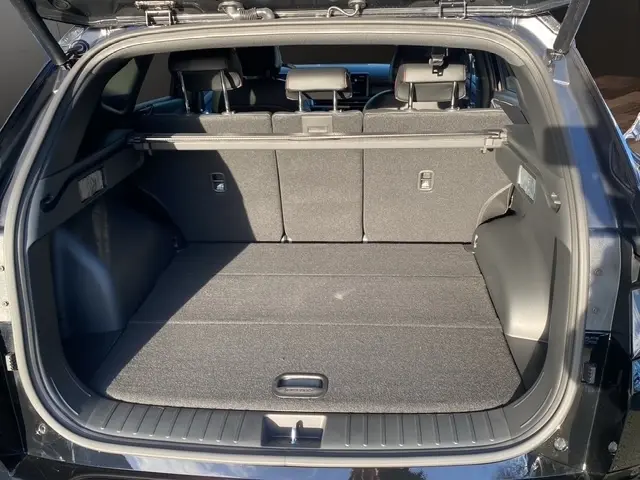 Coffre ouvert en vue arrière d’un Hyundai Tucson noir 2026, montrant l’espace de chargement et les sièges arrière rabattus.
