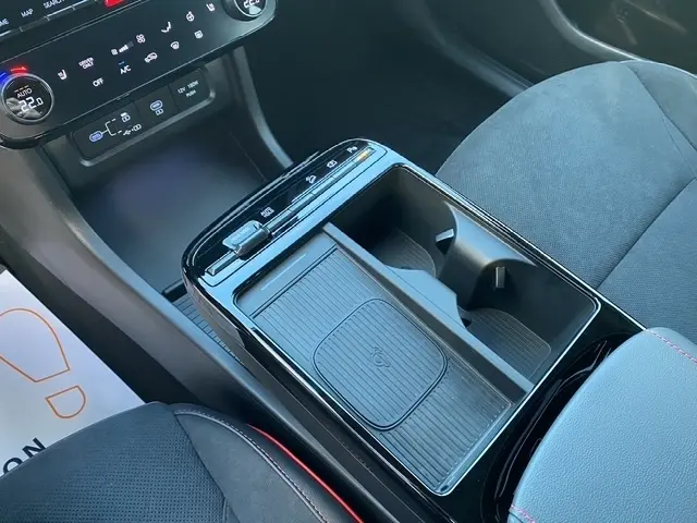 Vue rapprochée de la console centrale noire du Hyundai Tucson 1.6 Hybrid N Line avec rangement et commandes tactiles.