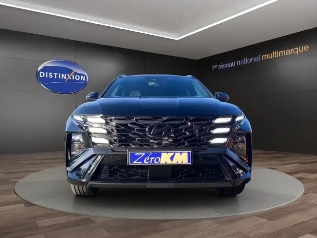 Vue frontale d'un Hyundai Tucson 1.6 Hybrid N Line Creative noir, avec calandre distinctive et éclairage LED allumé.