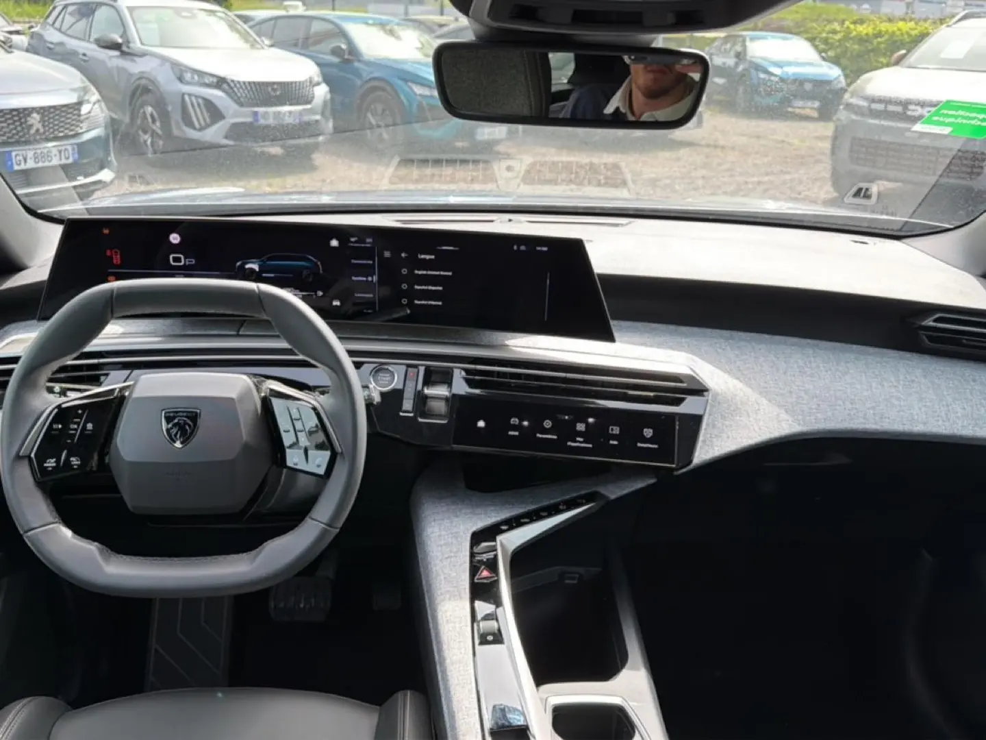 Vue intérieure du tableau de bord et volant cuir multifonction du Peugeot 5008 gris Artense, avec écran tactile panoramique.