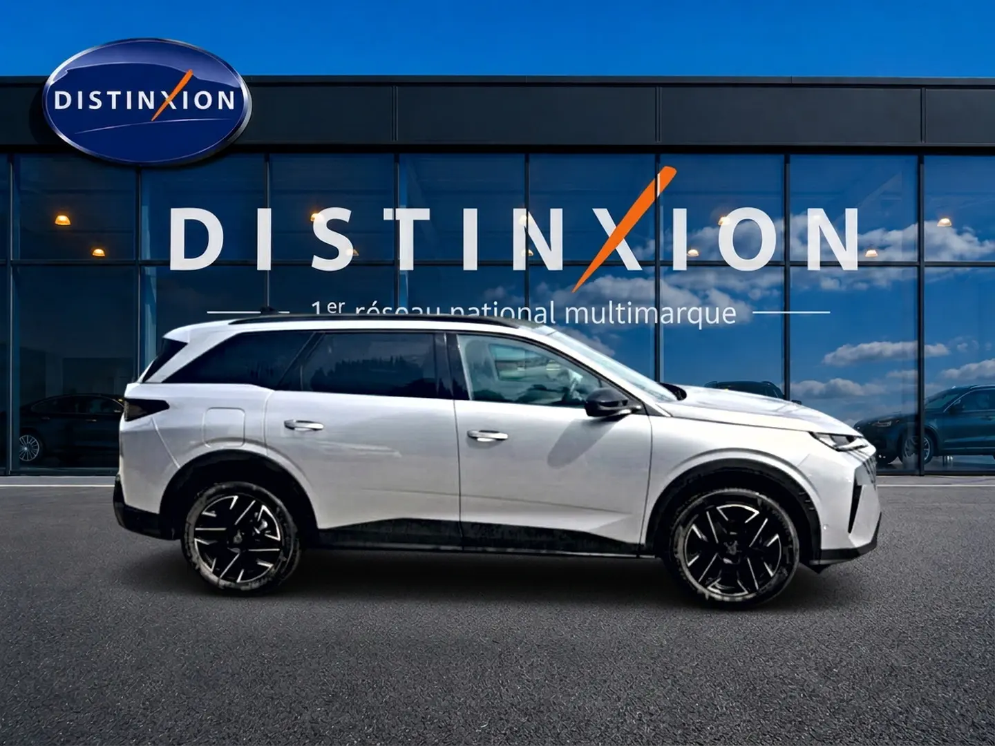 Peugeot 5008 Hybrid 145 allure e-dcs6 gris artense vue de profil côté gauche devant une vitrine Distinxion.