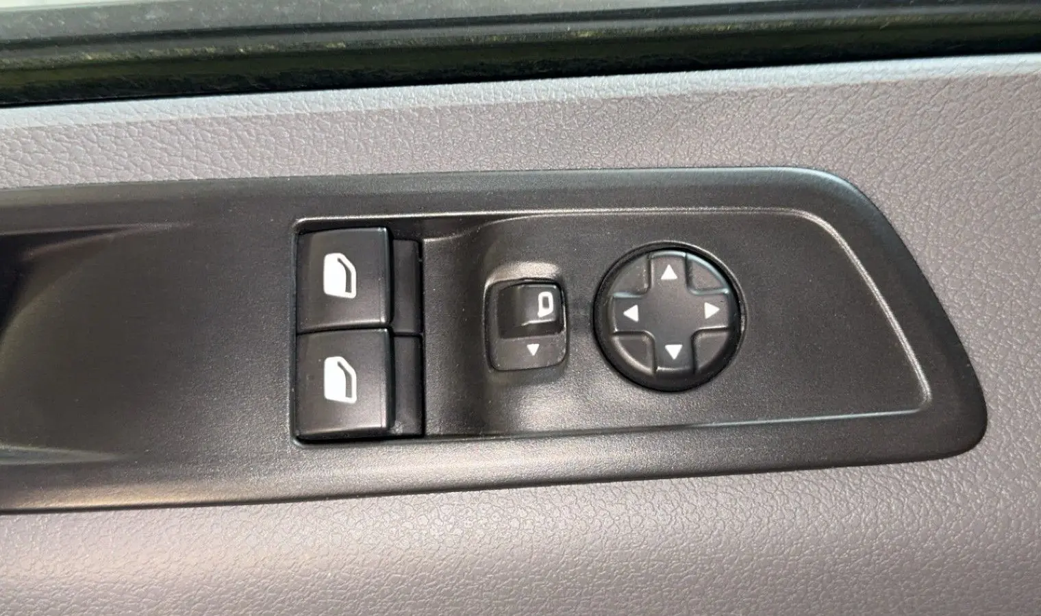 Commandes de réglage des rétroviseurs et des vitres sur la porte intérieure d'un Opel Vivaro Combi gris 2022.