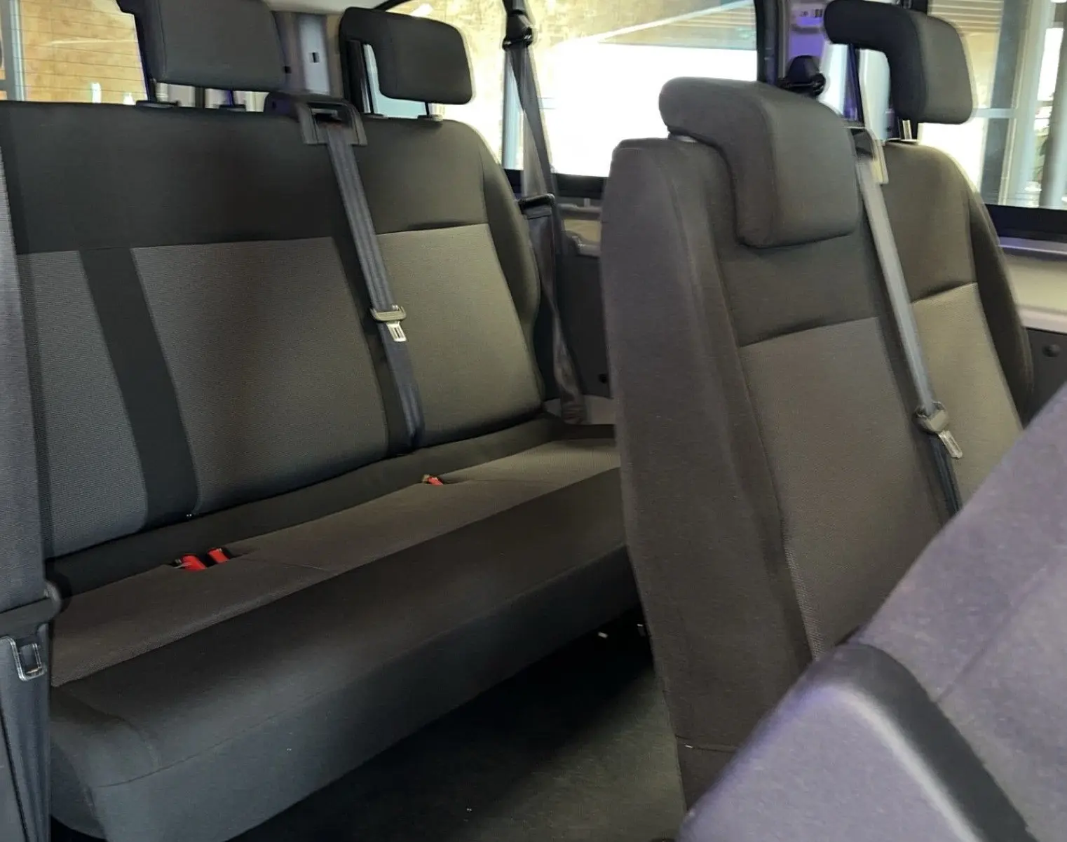 Vue intérieure des sièges arrière en tissu gris du Opel Vivaro Combi 2022, montrant la banquette et les appuie-têtes.