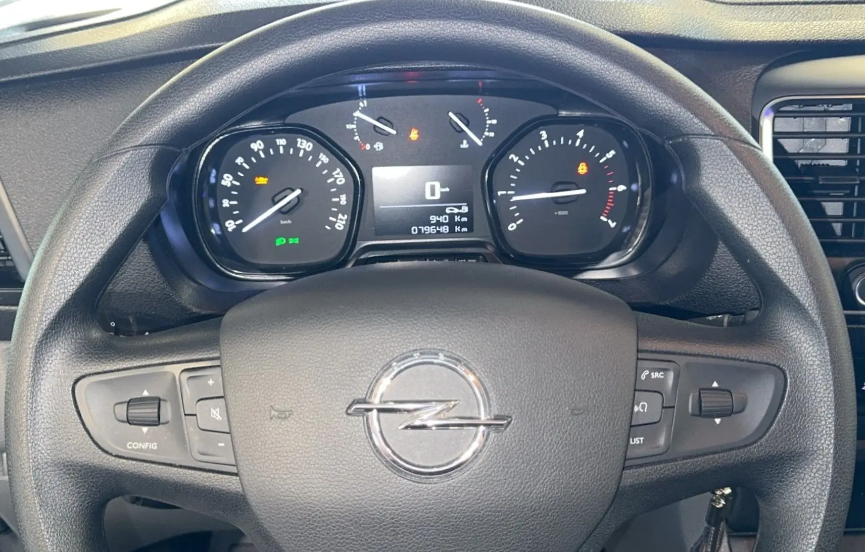 Vue rapprochée du volant noir d'un Opel Vivaro Combi 2022 avec tableau de bord numérique et commandes intégrées.