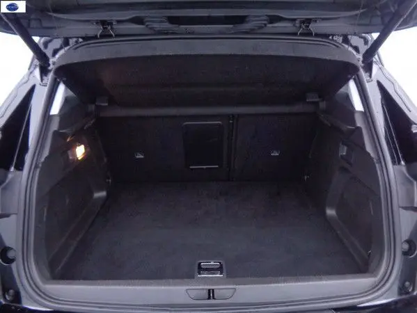 Coffre ouvert en vue arrière d’un Opel Grandland X noir métal, montrant un espace de chargement propre et spacieux.