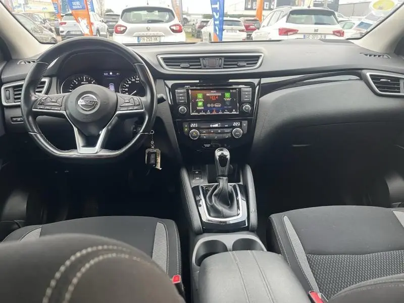 Intérieur noir du Nissan Qashqai 2020, vue frontale sur le tableau de bord et la console centrale avec boîte auto.