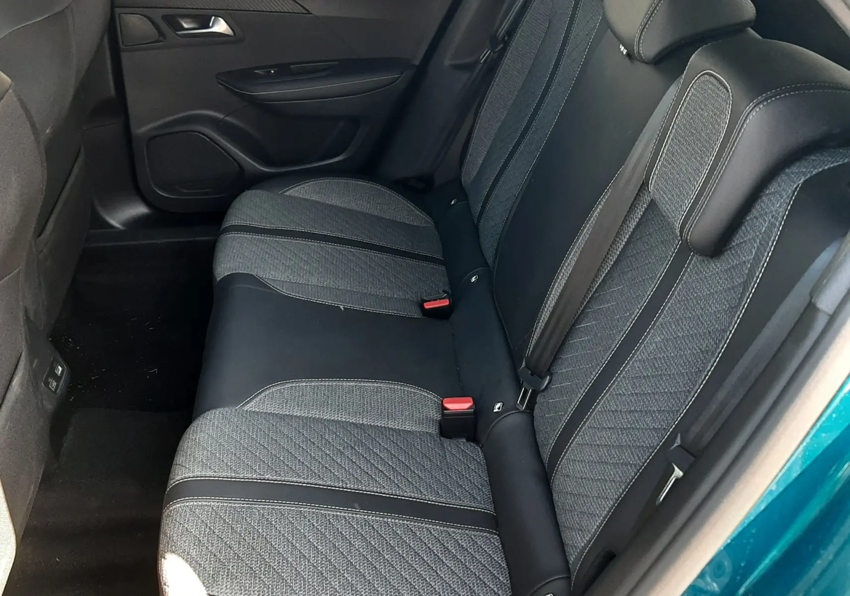 Vue intérieure côté droit des sièges arrière en tissu gris et noir du Peugeot 2008 Hybrid 145 Allure Bleu Obsession 2025.
