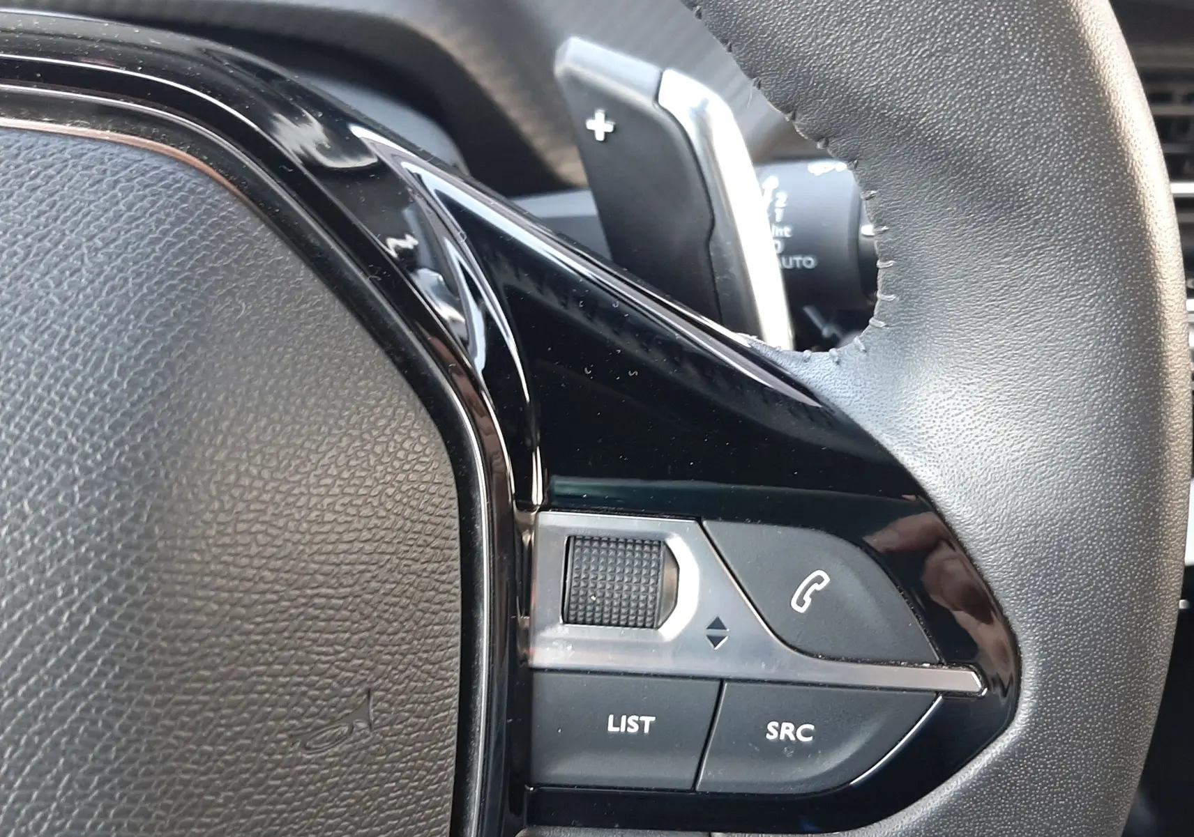 Gros plan sur la partie droite du volant noir du Peugeot 2008 Hybrid 145 Allure 2025 avec commandes intégrées.