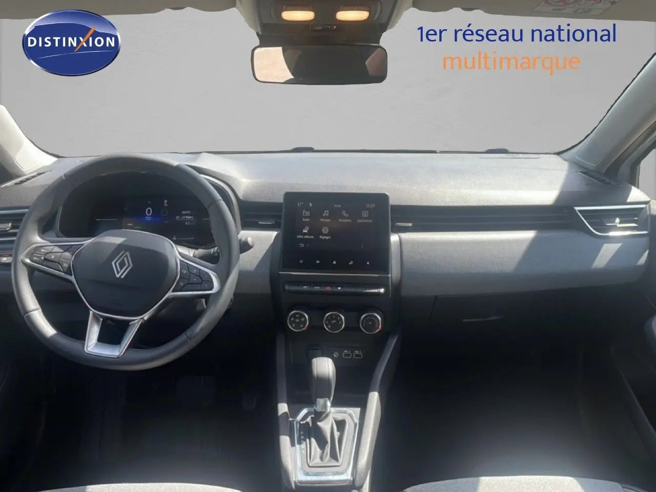 Vue intérieure avant de la Renault Clio 2025, tableau de bord moderne avec écran tactile central et volant multifonction.