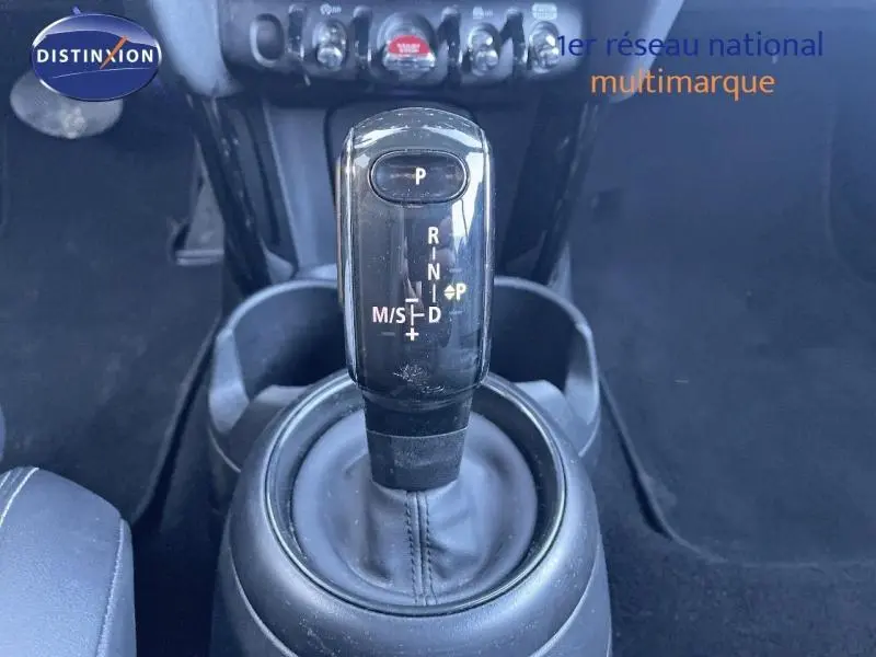 Le levier de vitesses automatique noir de la MINI Cabriolet Cooper 2023 vu de dessus, entouré de console et sièges.