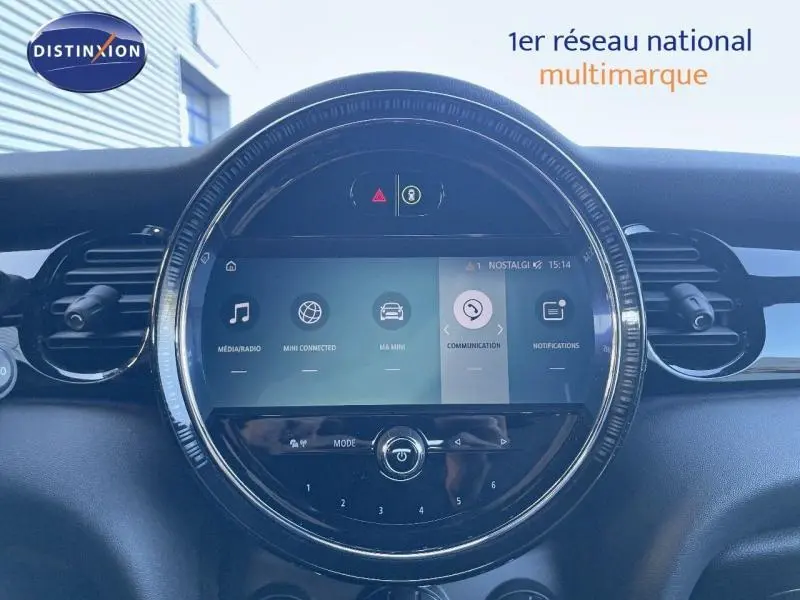 Écran tactile central rond du tableau de bord d'une MINI Cabriolet Midnight Black II, avec commandes multimédia visibles.