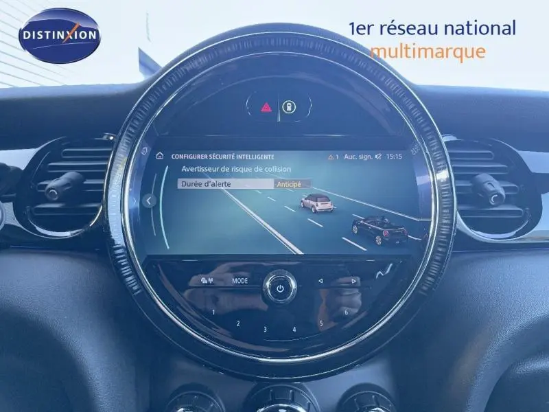 Écran tactile central rond du tableau de bord d'une MINI Cabriolet Midnight Black II, affichant l'alerte de collision.