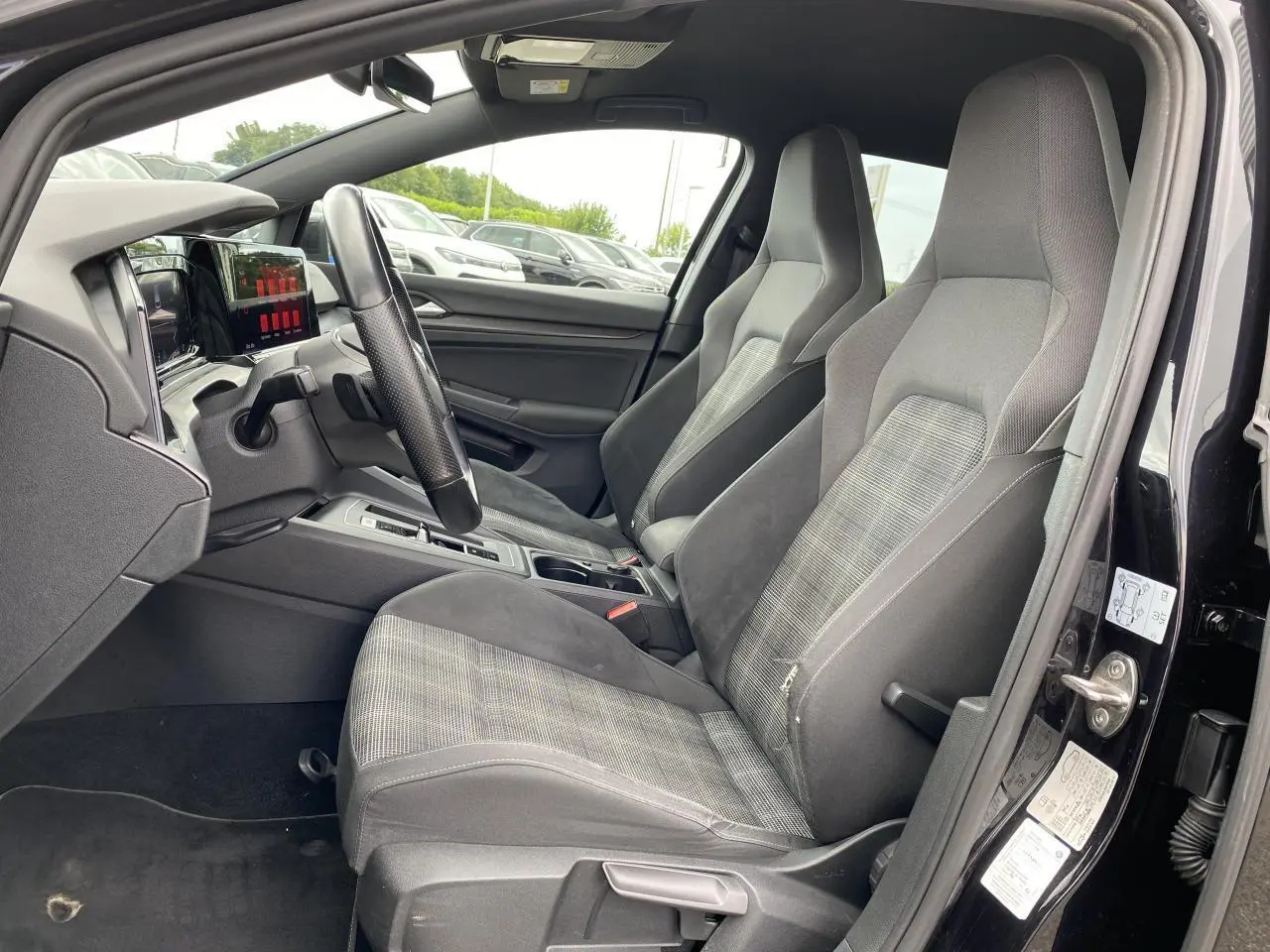 Intérieur de la Volkswagen Golf VIII GTD 2022, vue côté gauche, sièges sport tissu gris et tableau de bord moderne.