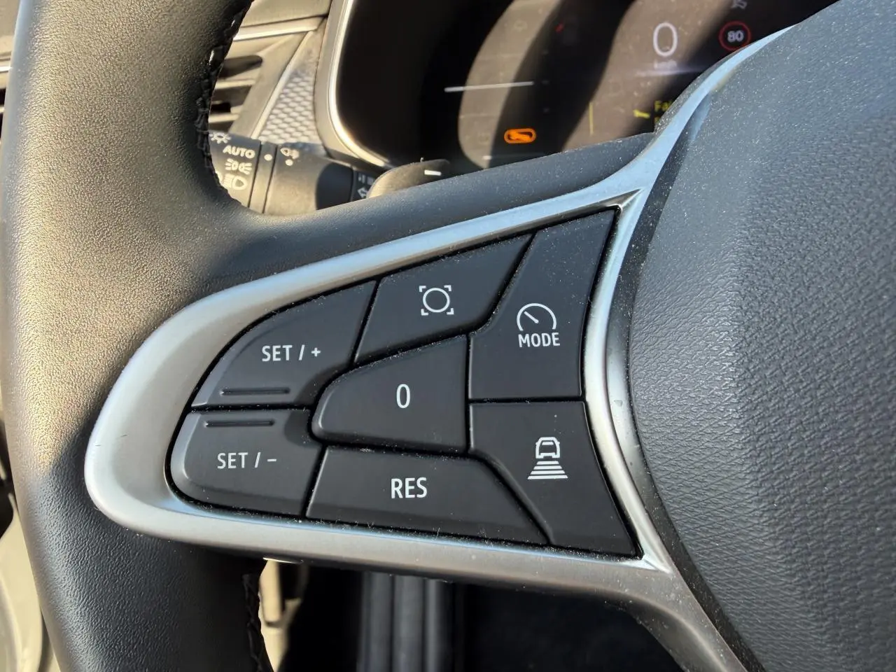 Gros plan sur les commandes du volant en textile noir du Renault Arkana blanc glacier, version 1.3 Mild Hybrid 2025.