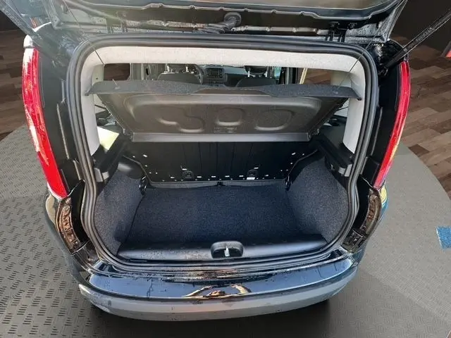 Coffre ouvert vu de l'arrière d'une Fiat Panda noire 2025, montrant l'espace de chargement et la tablette arrière relevée.