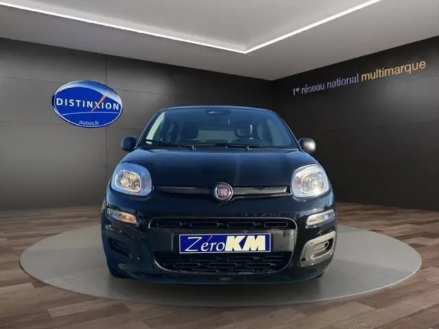 Vue frontale d'une FIAT Panda noire 2025 dans un showroom avec plaque d'immatriculation Zero KM visible.