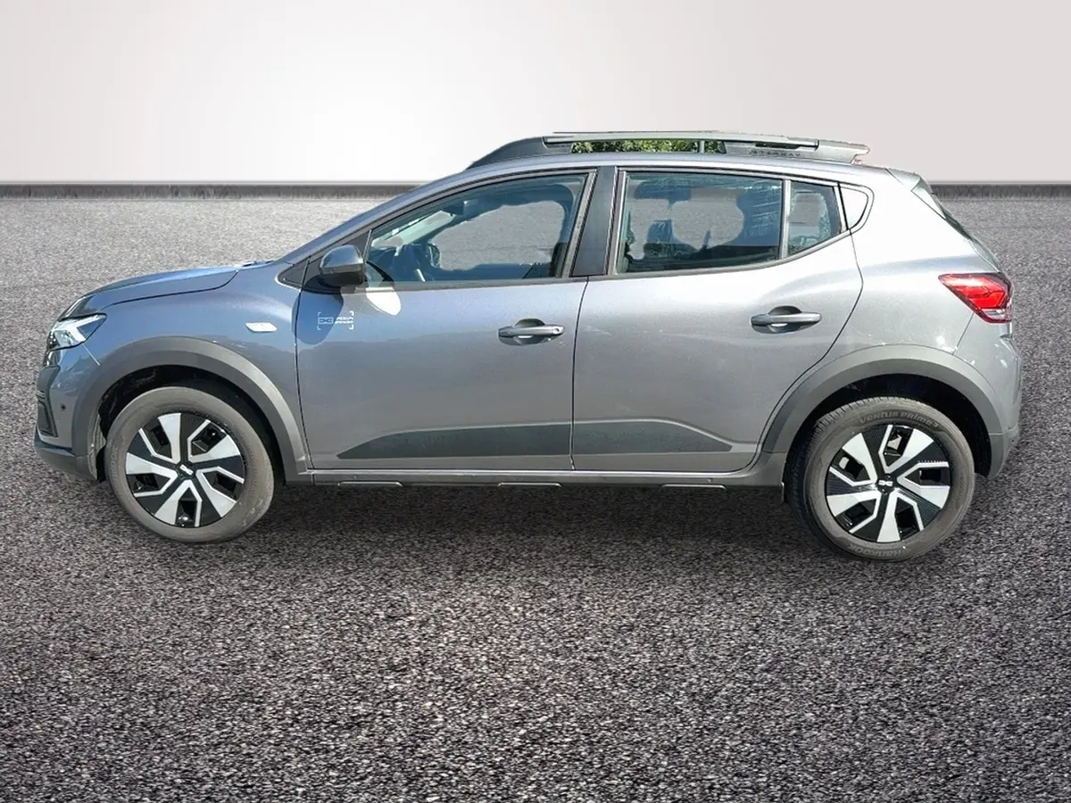 Profil côté gauche d'une Dacia Sandero Stepway gris foncé avec barres de toit et jantes distinctives.