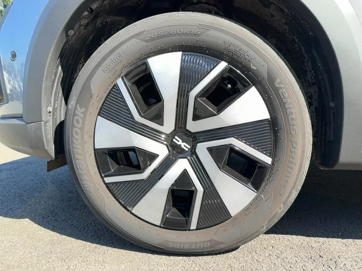 Gros plan sur la roue avant droite d'une Dacia Sandero Stepway gris foncé avec jante au design noir et argent.
