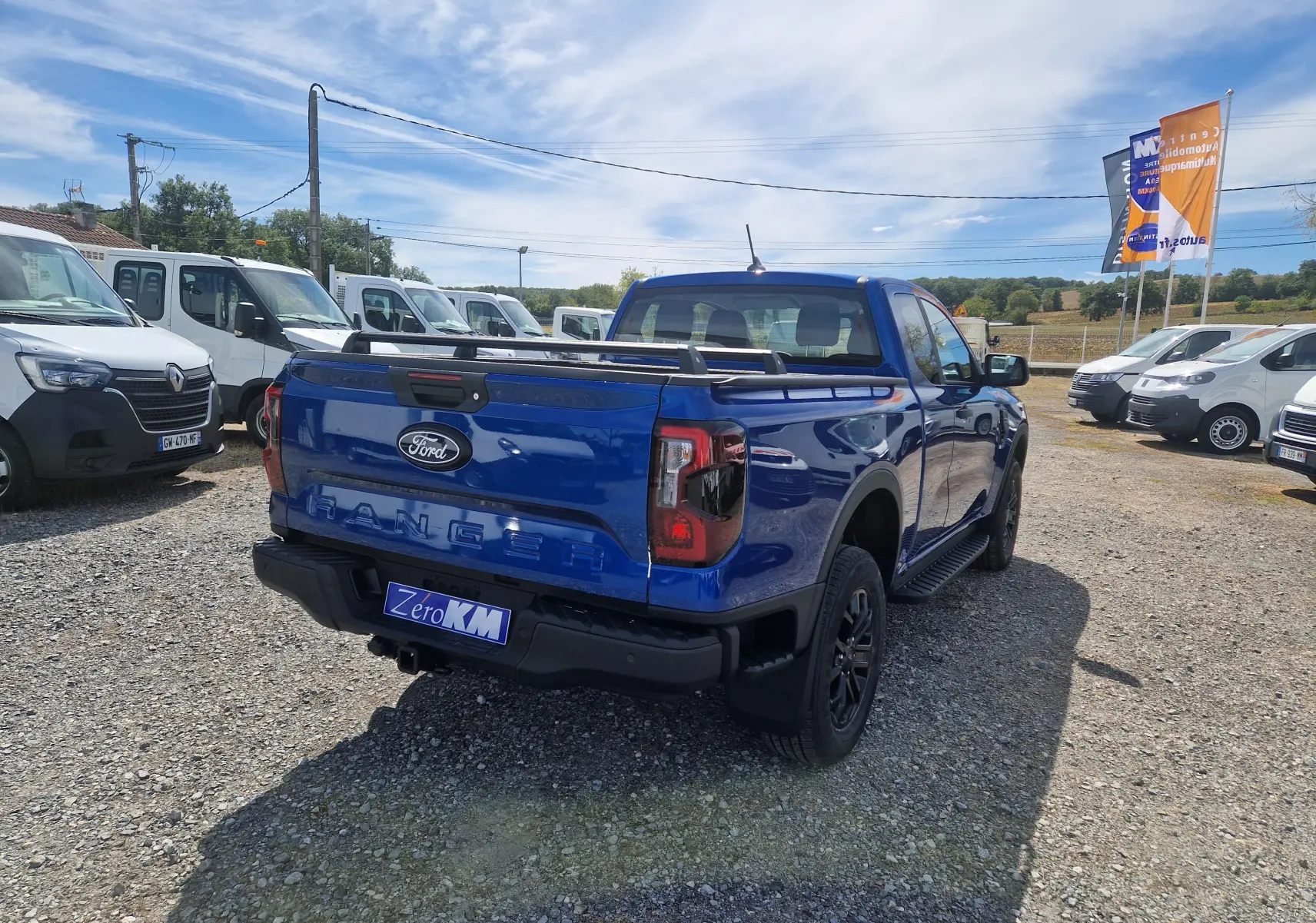 Vue 3/4 arrière droite du Ford Ranger Super Cabine bleu Lightning avec rideau de plateau et barres sur plateau.