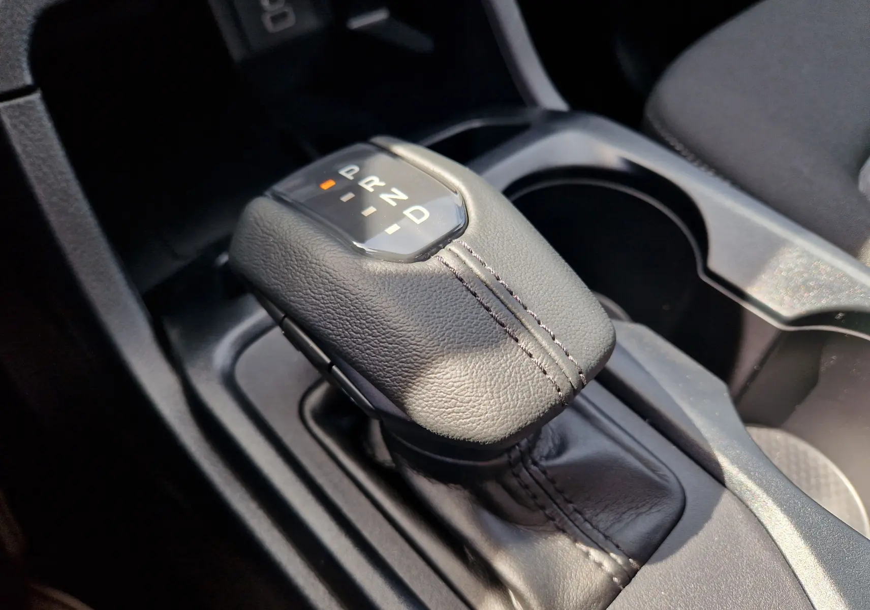 Gros plan sur le levier de vitesses automatique en cuir noir du Ford Ranger Super Cabine bleu Lightning.