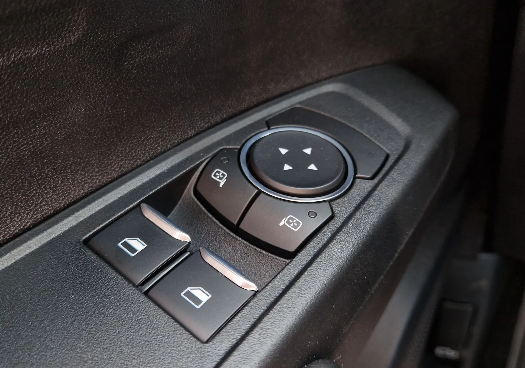 Gros plan sur les commandes de réglage des rétroviseurs et des vitres côté conducteur du Ford Ranger Super Cabine bleu Lightning.
