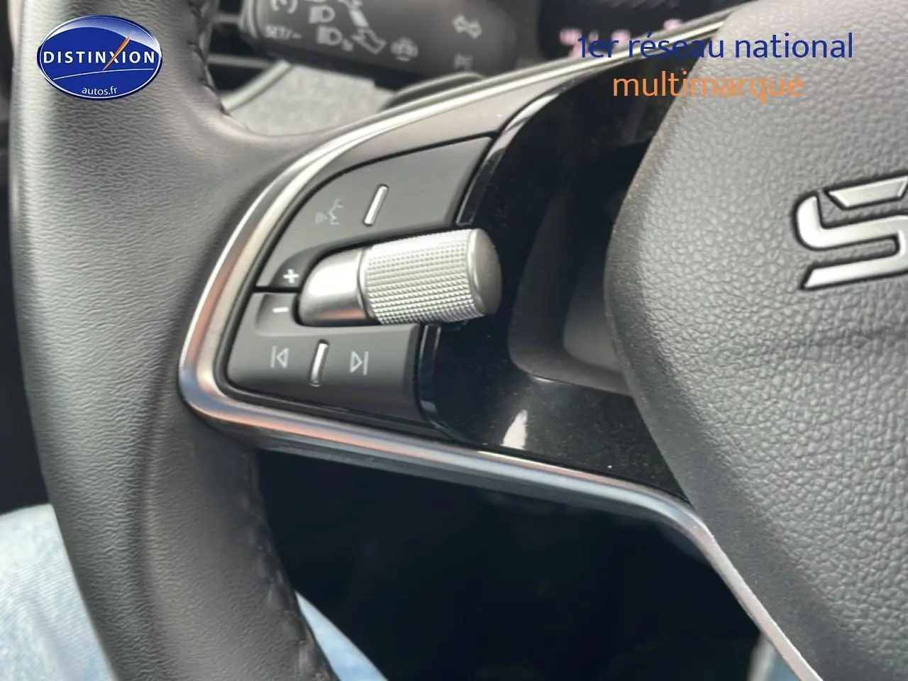 Gros plan sur les commandes gauche du volant cuir noir du Skoda Kamiq gris 2025, avec molette et boutons multifonctions.