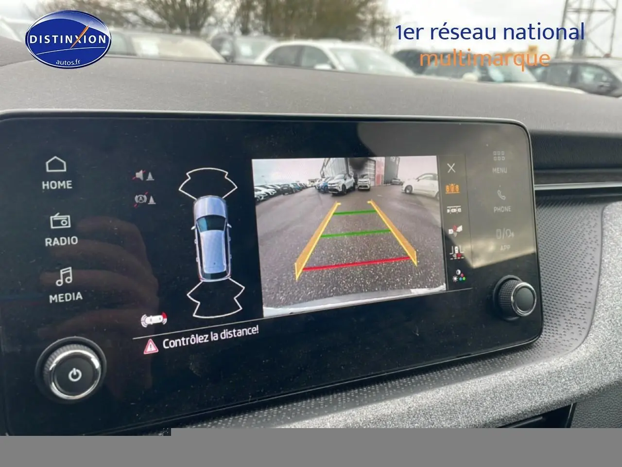 Écran tactile intérieur montrant la caméra de recul du Skoda Kamiq gris, avec aides au stationnement affichées.