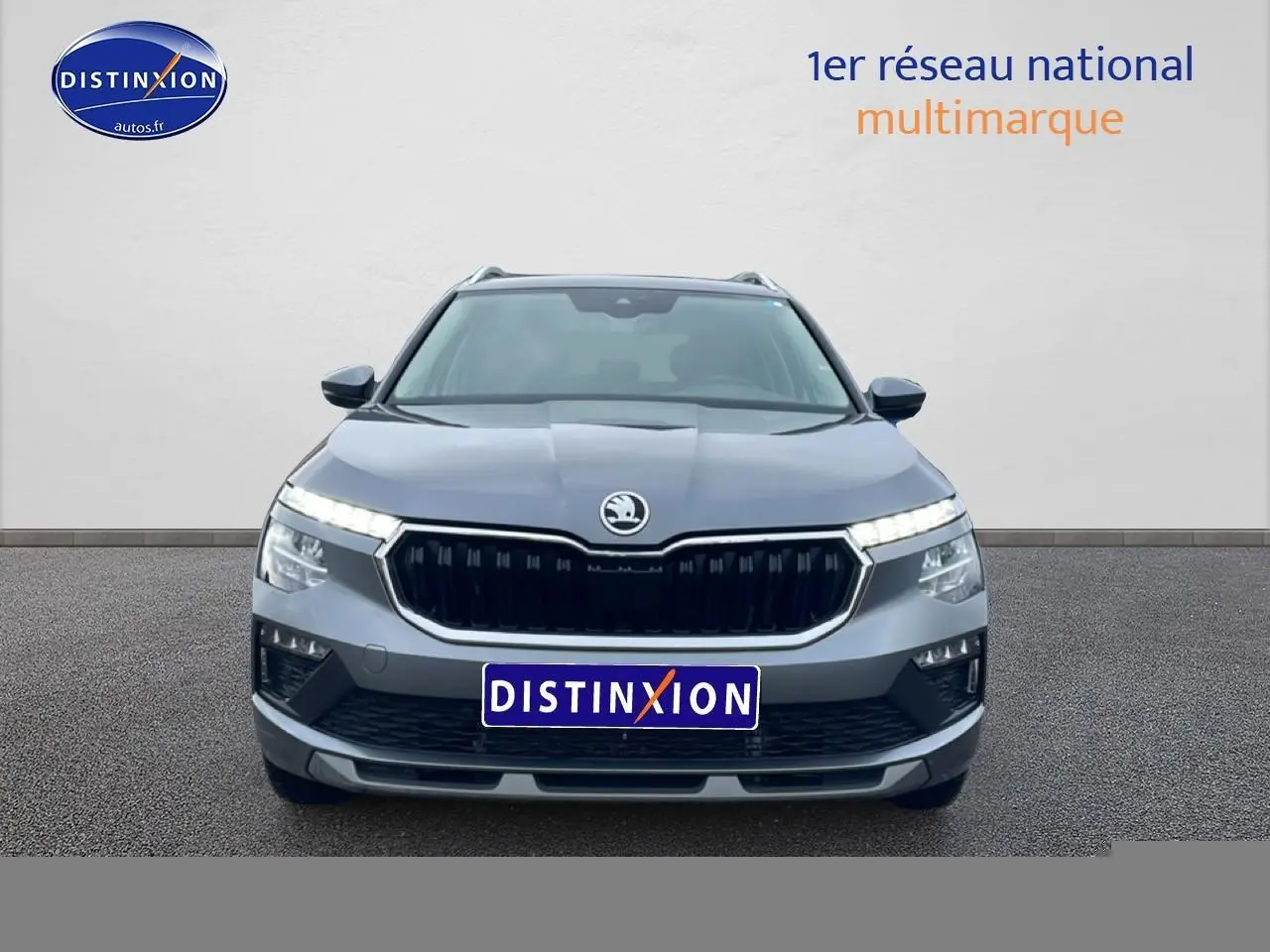 Vue frontale d'un Skoda Kamiq gris 2025 avec calandre noire et feux LED distinctifs allumés.