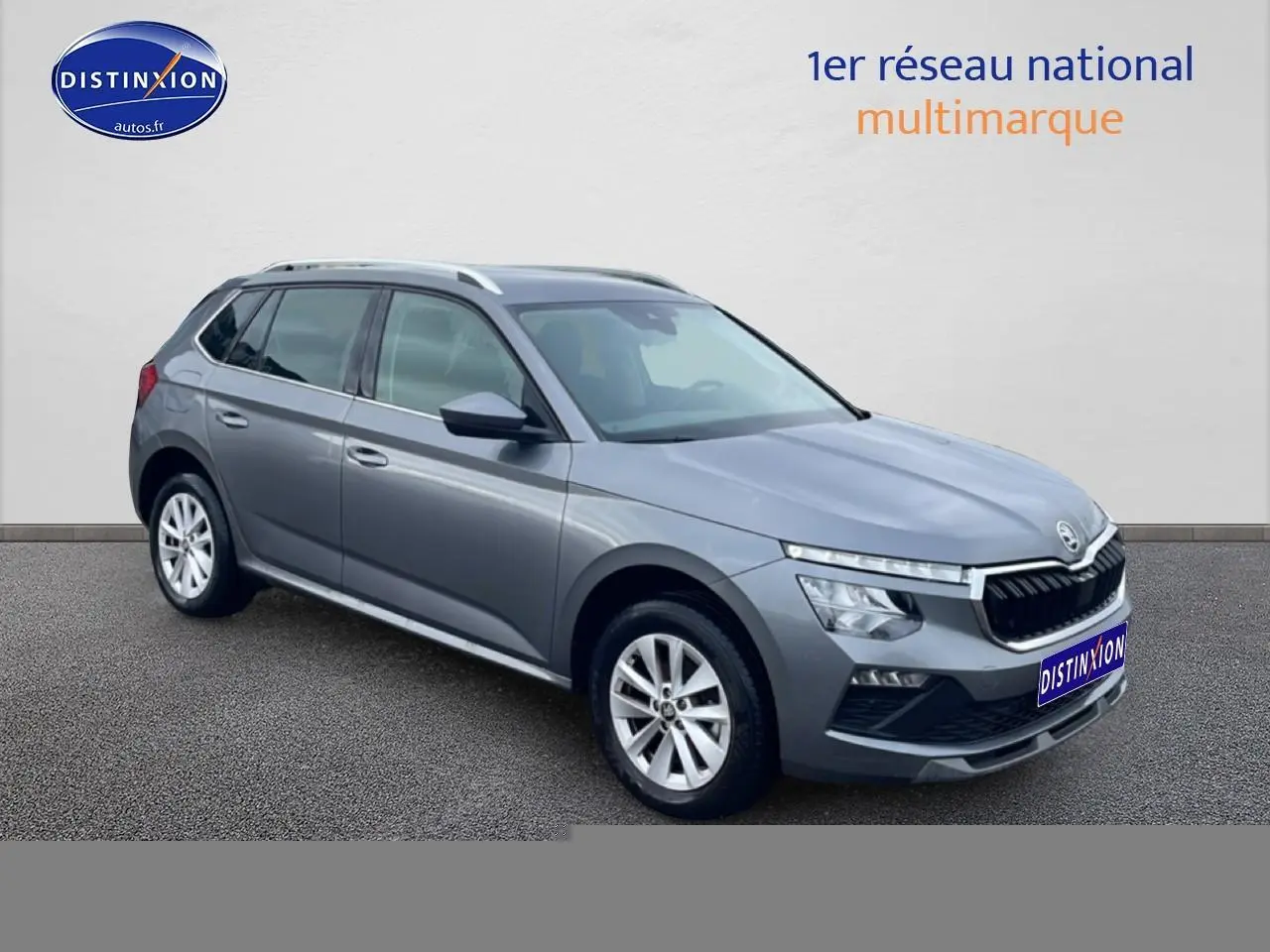 Vue 3/4 avant droit d'un Skoda Kamiq gris 2025 avec calandre chromée et jantes alu.