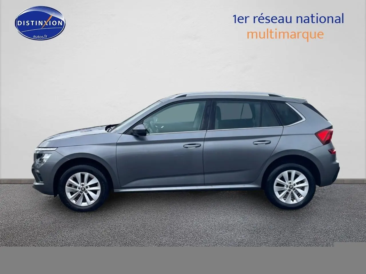 Profil droit d'un Skoda Kamiq gris 2025 avec jantes alu et barres de toit visibles sur fond neutre.