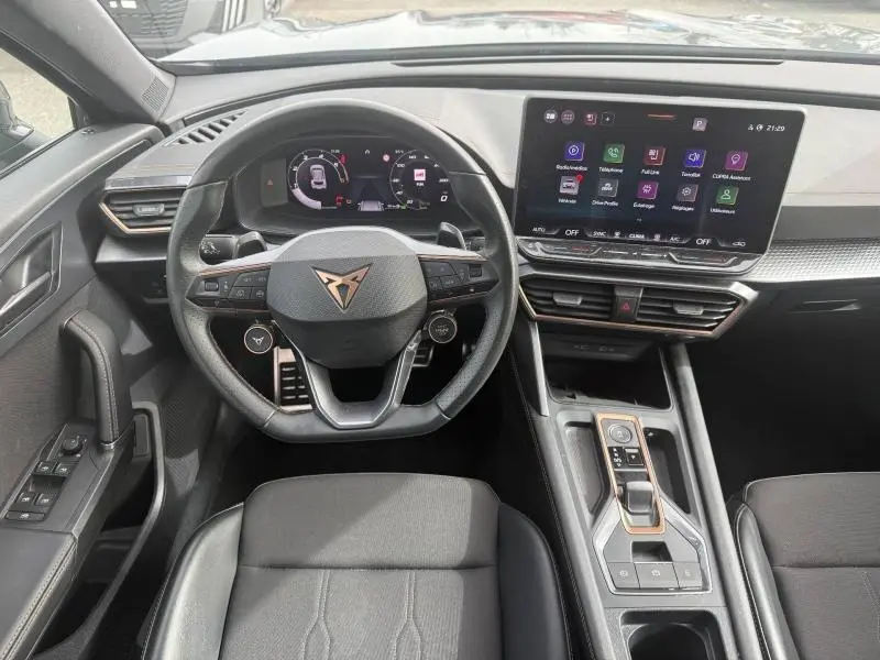 Vue intérieure avant centrée sur le volant multifonction et l'écran tactile du tableau de bord du CUPRA Formentor 2025.