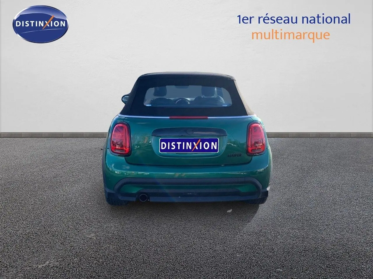 Vue arrière d'une MINI Cabriolet F57 1.5 136CH en British Racing Green avec capote noire fermée.