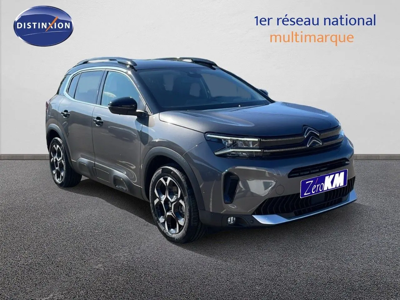 Vue 3/4 avant d'un Citroën C5 Aircross gris platinium avec toit noir, jantes bi-ton et calandre moderne.