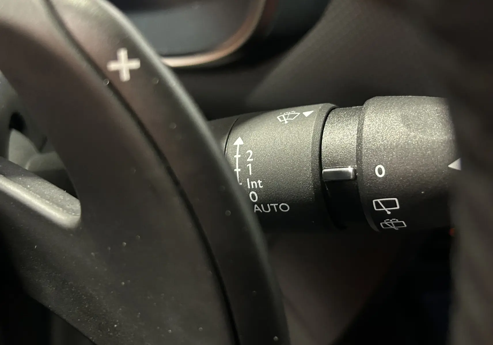 Gros plan sur la manette de commande des essuie-glaces à droite du volant dans l'habitacle d'une Citroën C5 Aircross.