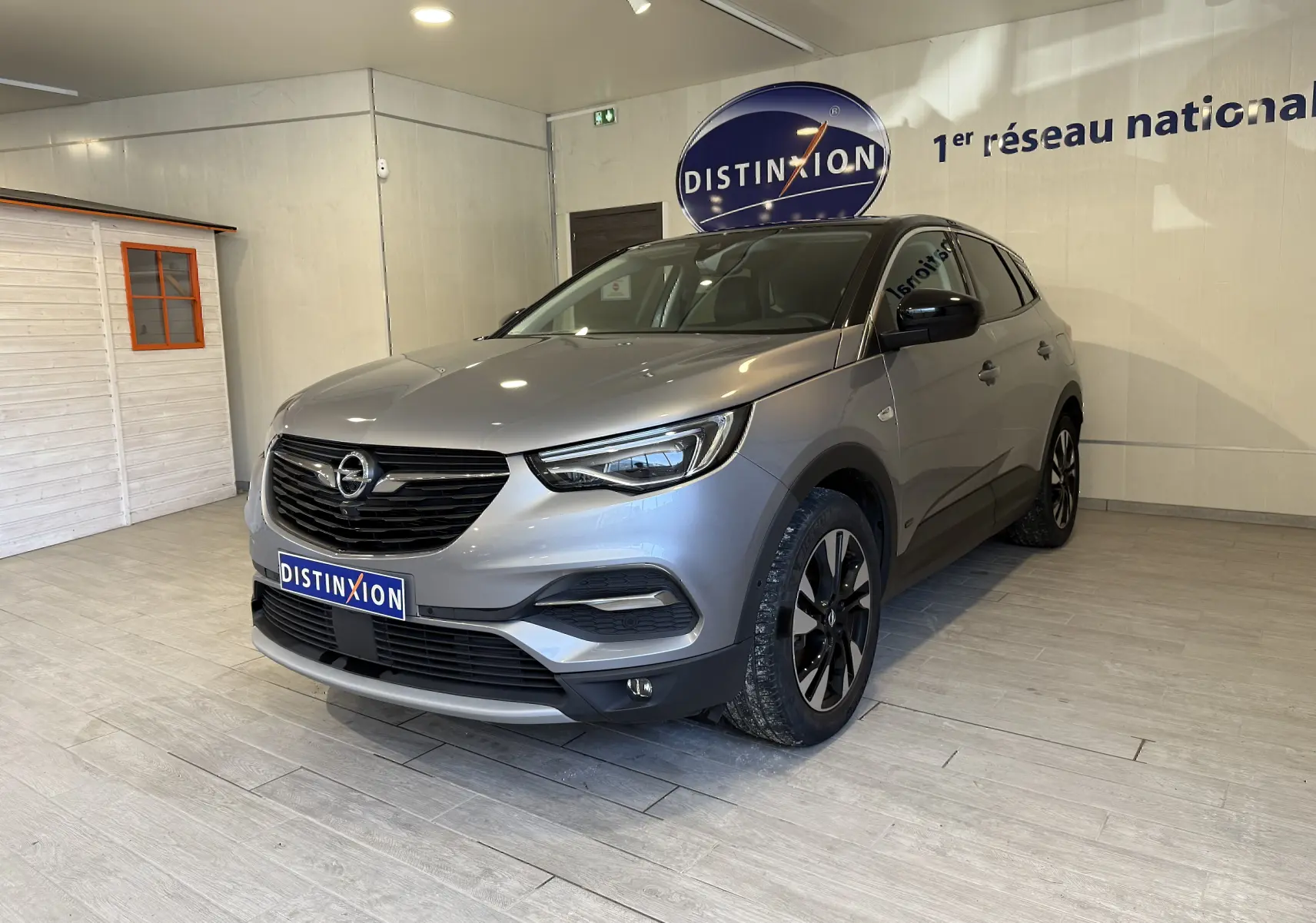 Opel Grandland X gris Himalaya en 3/4 avant droit, avec calandre noire et jantes alliage bicolores.