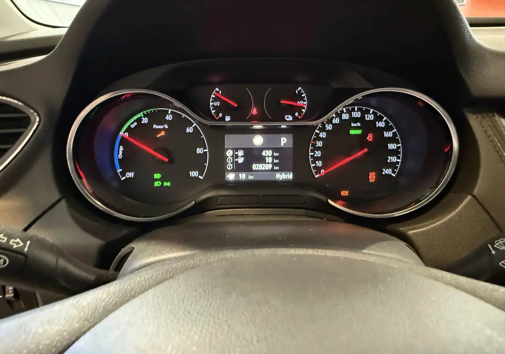 Tableau de bord de l'Opel Grandland X hybride, affichage numérique et compte-tours éclairé en vue frontale.