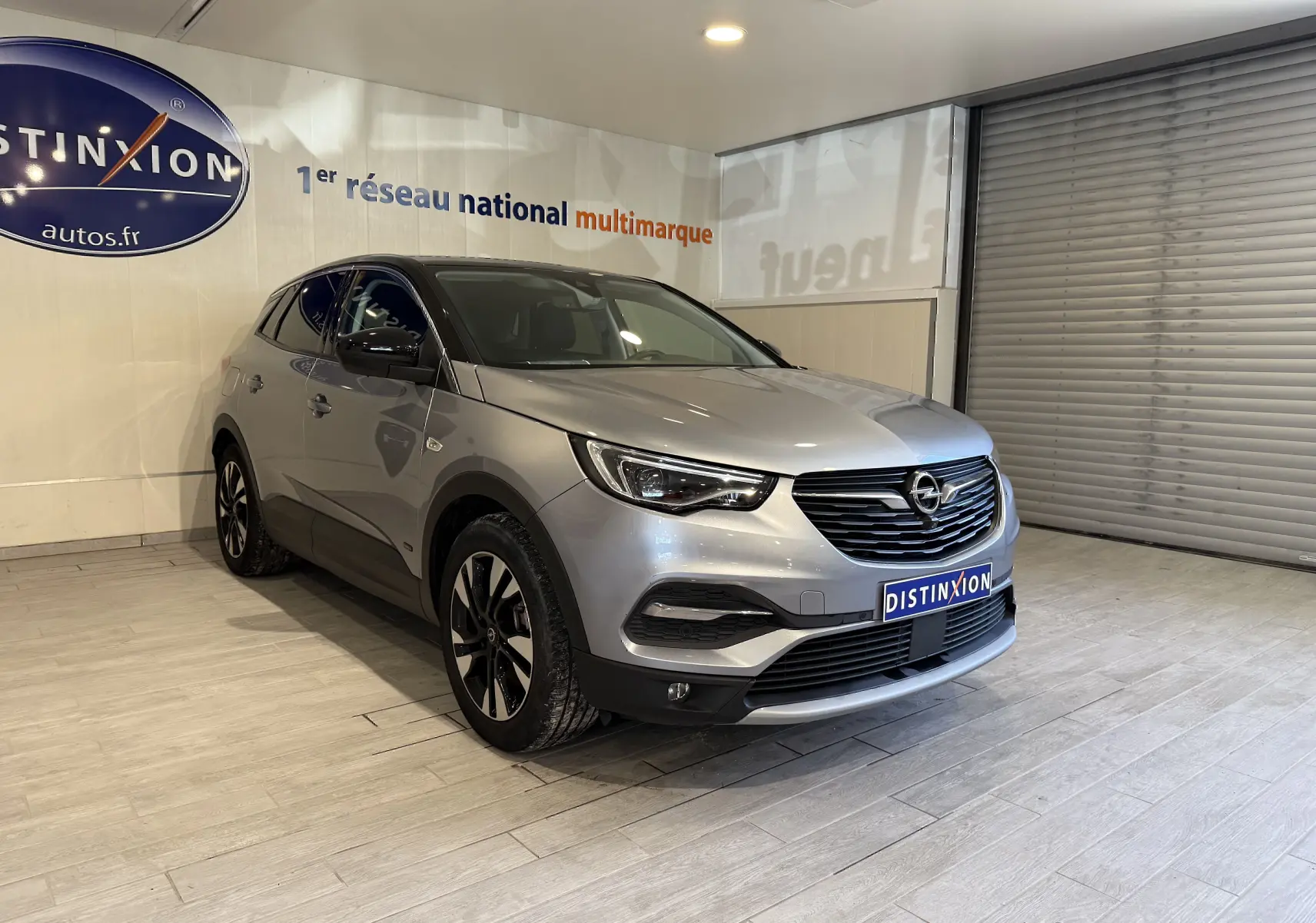 Opel Grandland X gris Himalaya en 3/4 avant droit, SUV hybride rechargeable avec jantes alliage et calandre noire.