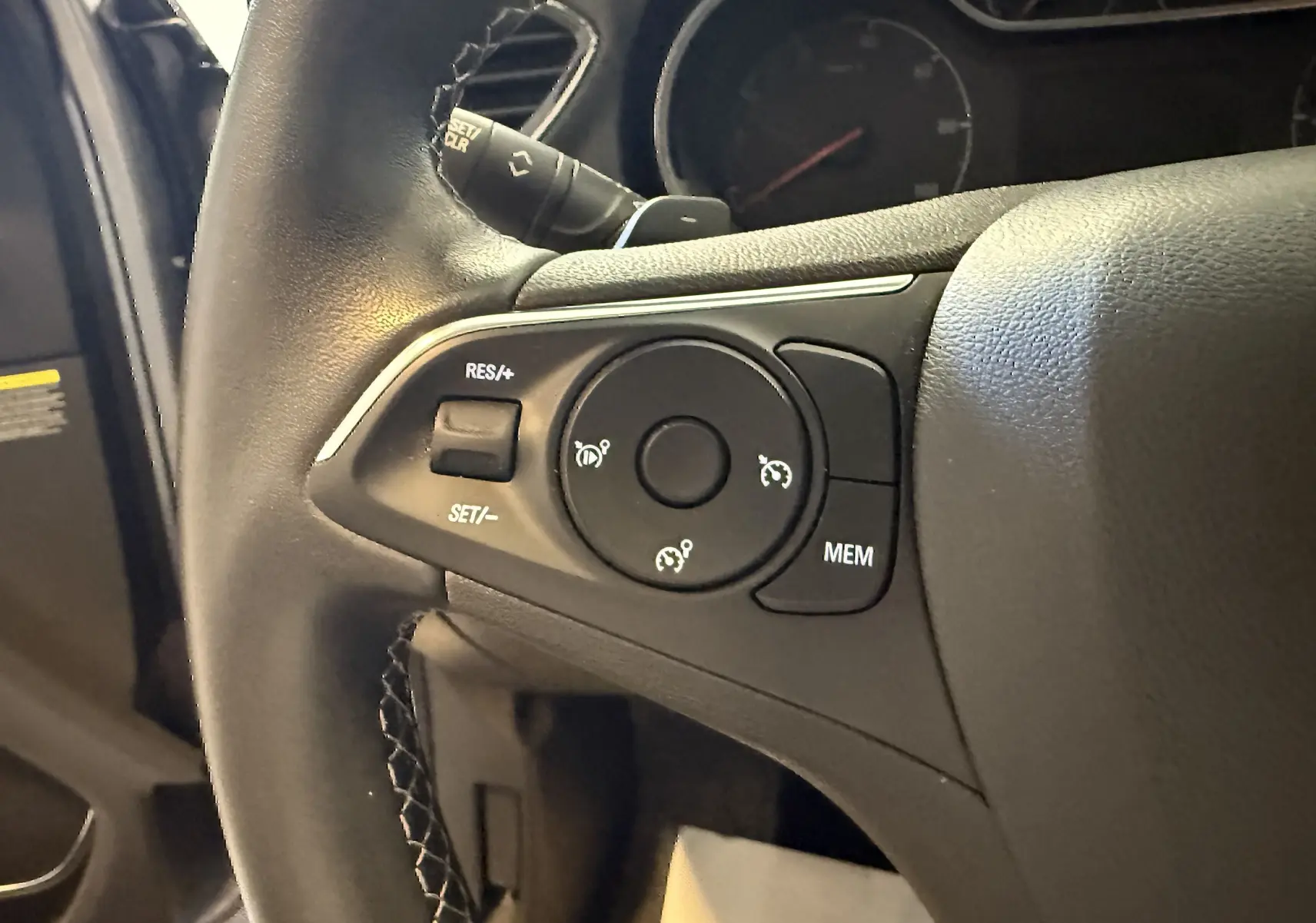 Gros plan sur les commandes de régulateur de vitesse au volant noir de l'Opel Grandland X hybride 2021.