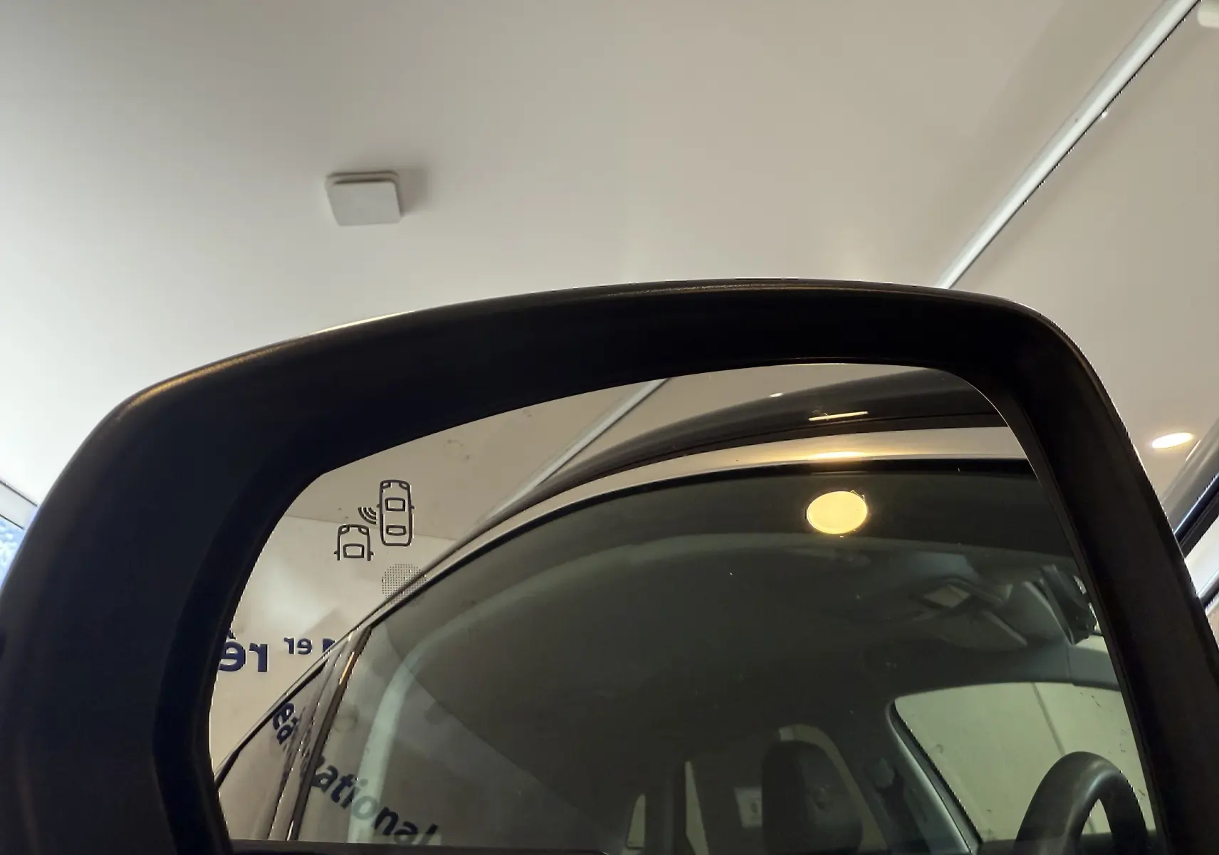 Rétroviseur côté gauche montrant la portière gris Himalaya métal et l'intérieur du Opel Grandland X hybride 2021.