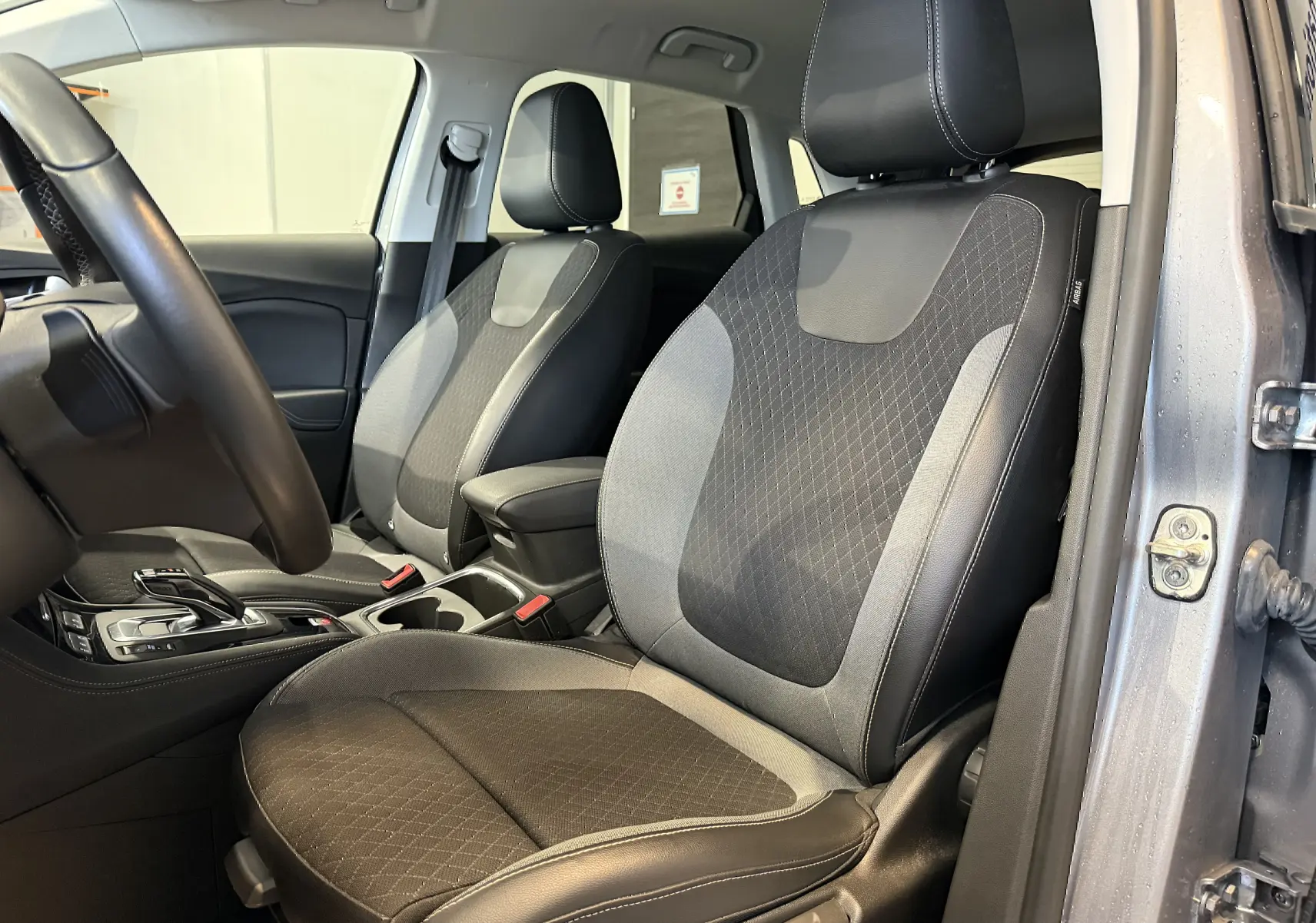 Intérieur avant droit de l'Opel Grandland X gris Himalaya, sièges tissu et cuir avec surpiqûres blanches visibles.