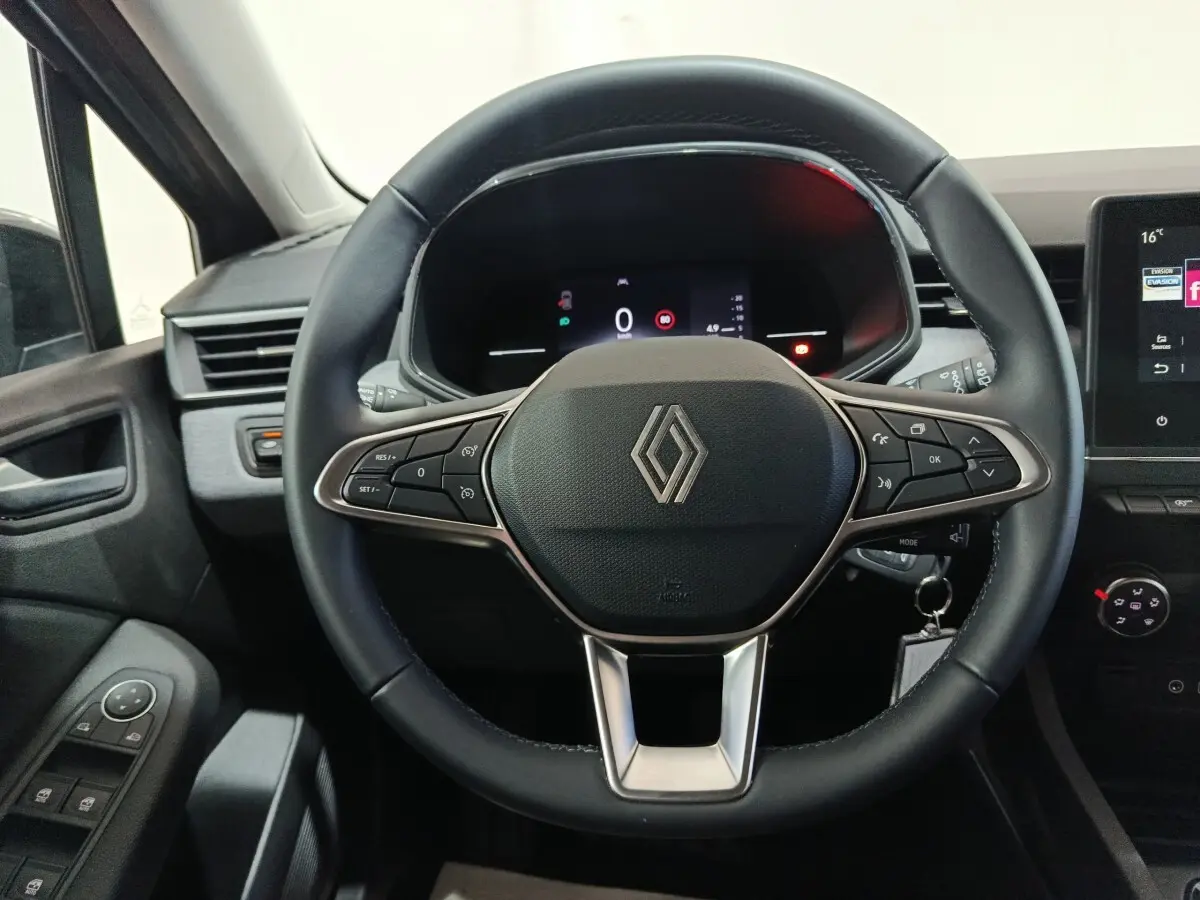 Vue intérieure centrée sur le volant cuir multifonctions de la Renault Clio Evolution Blue dCi 100, tableau de bord numérique visible.