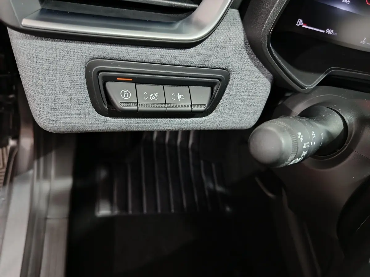 Détail du tableau de bord gris clair de la Renault Clio Evolution Blue dCi 100, avec commandes d’éclairage et verrouillage.