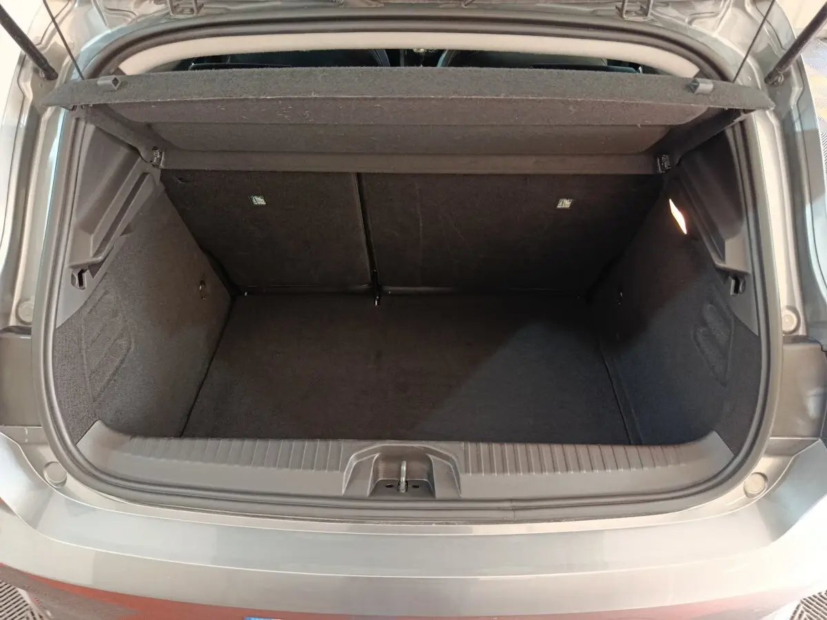 Coffre ouvert vu de l'arrière d'une Renault Clio gris clair 2025, montrant l'espace de chargement vide et la tablette arrière.