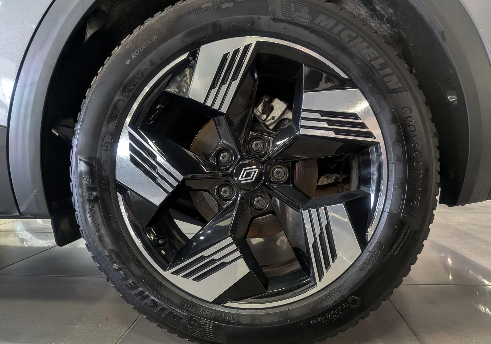 Gros plan sur la jante bicolore noire et argent du Renault Symbioz gris Cassiopé, avec pneu Michelin CrossClimate visible.