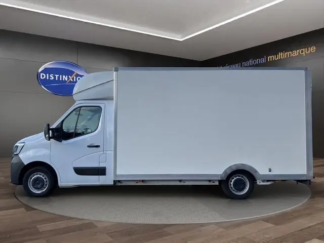Vue de profil côté gauche d’un utilitaire Renault Master blanc avec caisse fermée, présenté en intérieur showroom.