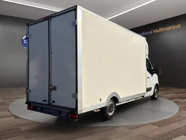 Vue 3/4 arrière droite d’un utilitaire blanc Renault Master avec caisse fermée et portes arrière battantes.